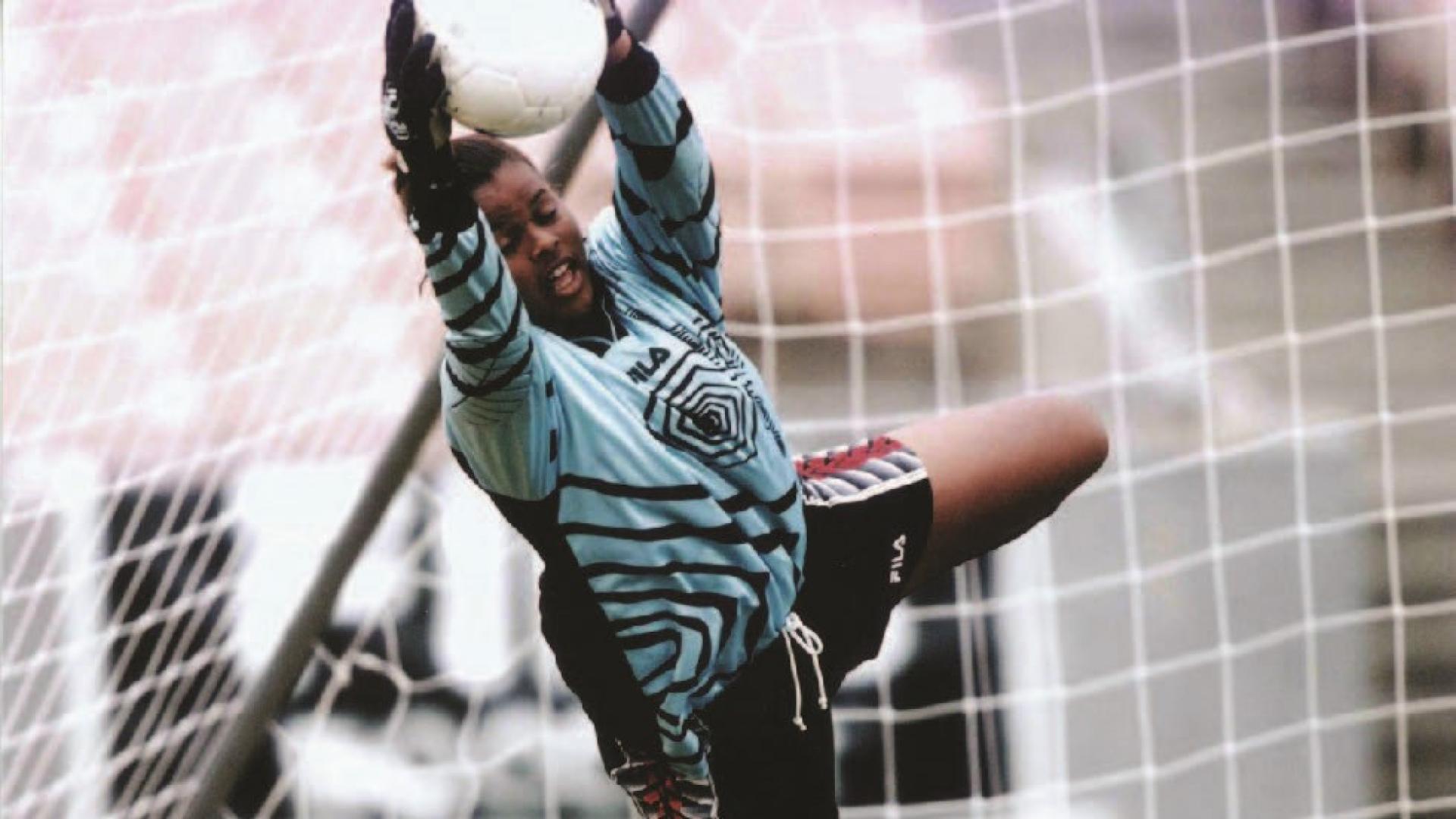 Karina LeBlanc jumps to grab a soccer ball out of the air before it can enter the goal.